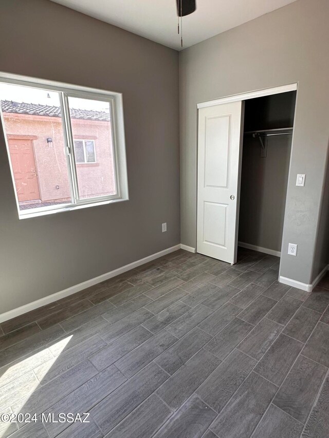 unfurnished bedroom featuring dark hardwood / wood-style flooring and a closet