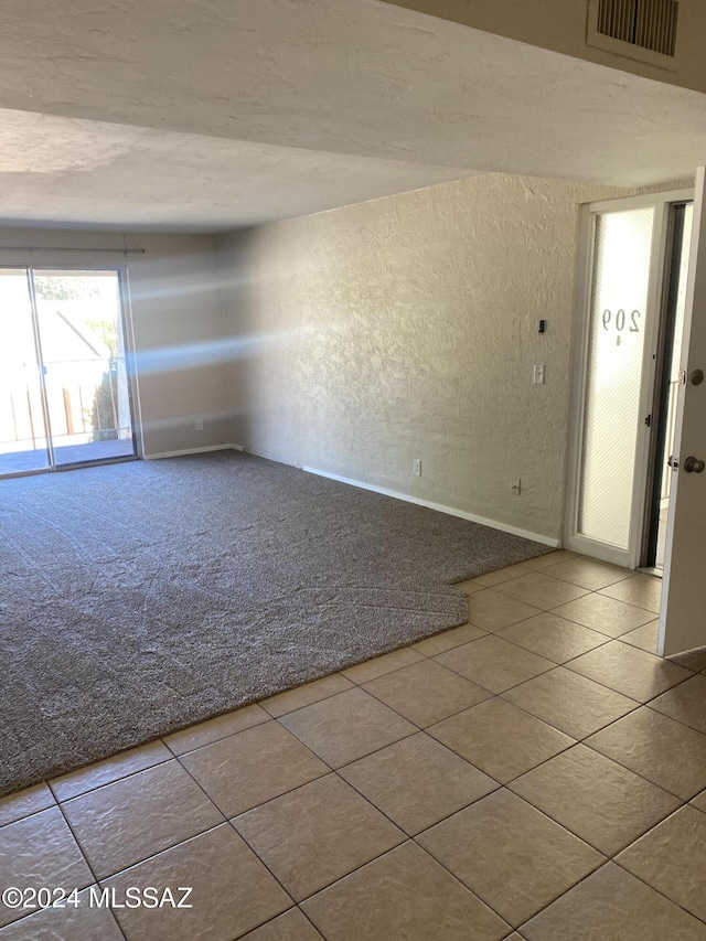 625 S Prudence Rd Unit 209, Tucson, AZ 85710 - carpeted spare room featuring a textured wall, tile patterned floors, and baseboards