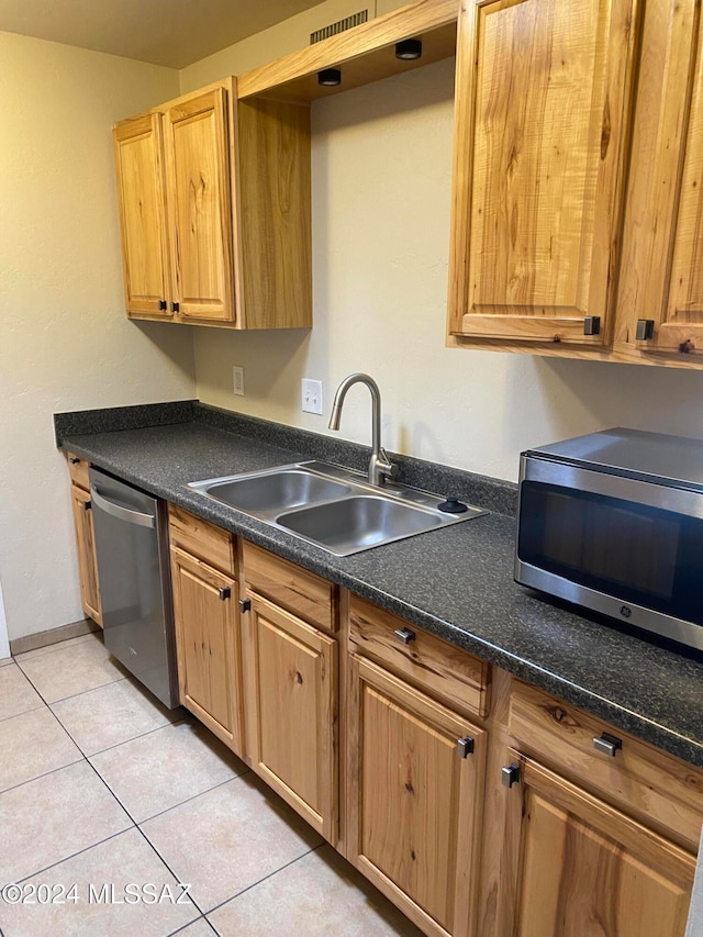 kitchen with sink, light tile patterned floors, and stainless steel appliances