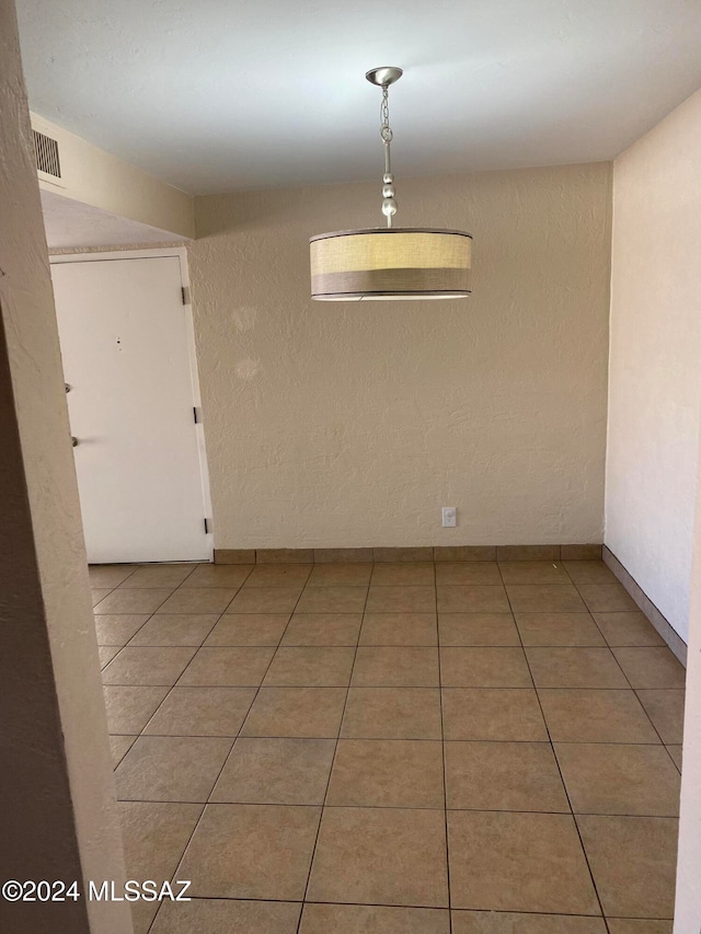 unfurnished dining area featuring tile patterned floors