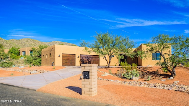 adobe home featuring a garage and a mountain view