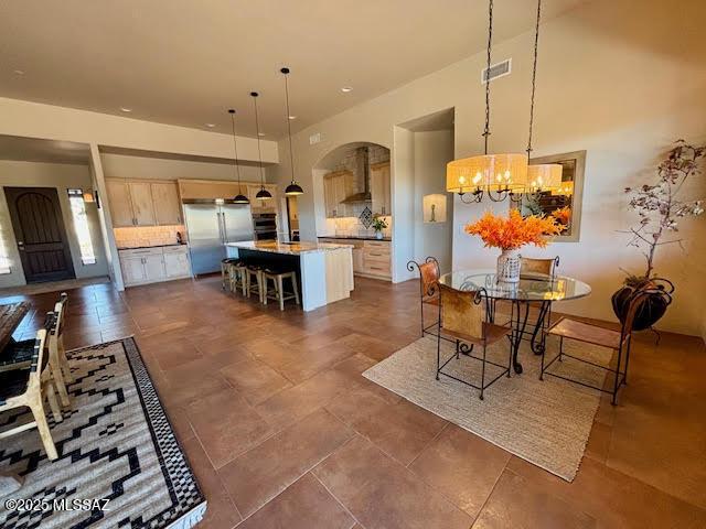 dining area featuring a high ceiling and a notable chandelier