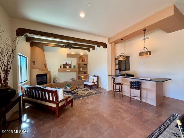 living room featuring beam ceiling and a fireplace