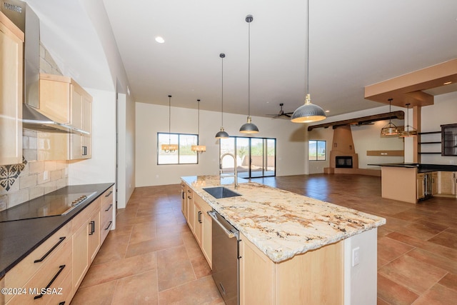 kitchen featuring wall chimney exhaust hood, light brown cabinetry, dishwasher, and an island with sink