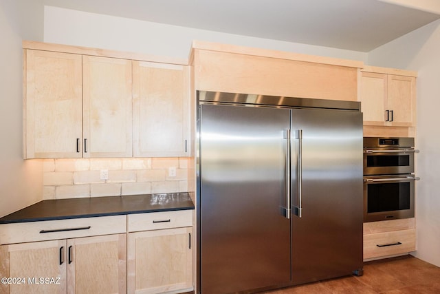 kitchen featuring decorative backsplash, stainless steel appliances, and light brown cabinets