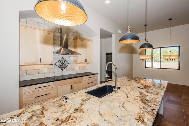 kitchen featuring sink, light brown cabinets, dark stone counters, wall chimney range hood, and black electric cooktop