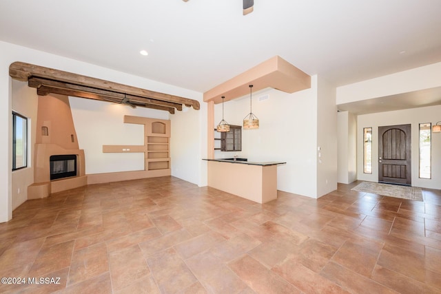 unfurnished living room featuring beam ceiling and a fireplace