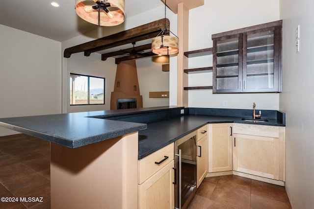 kitchen with sink, kitchen peninsula, dark tile patterned floors, beamed ceiling, and beverage cooler