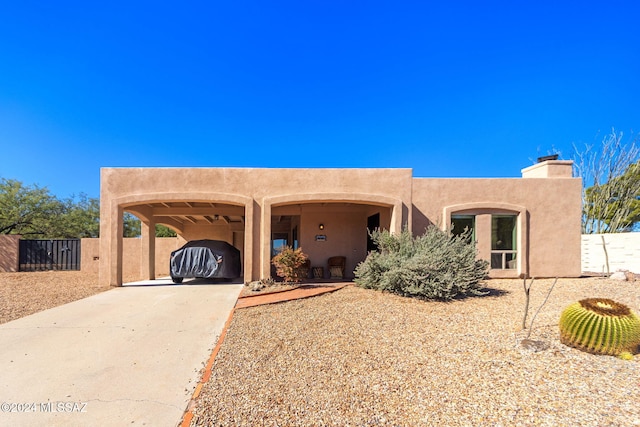 pueblo-style home featuring a carport