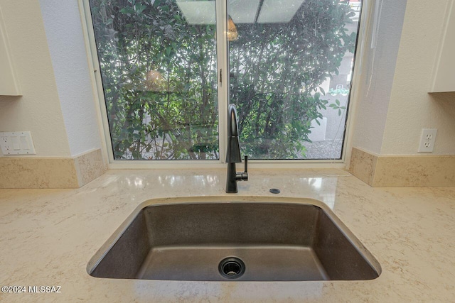 interior details featuring light stone counters and sink