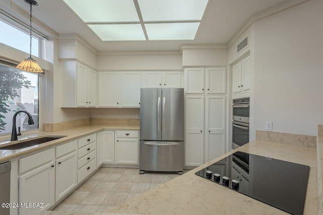 kitchen with white cabinetry, sink, hanging light fixtures, light tile patterned floors, and appliances with stainless steel finishes