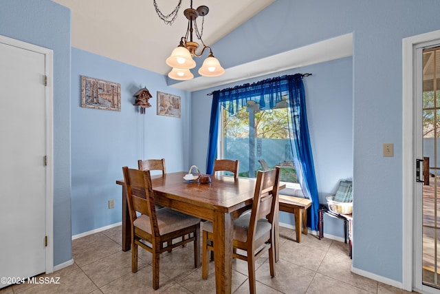 tiled dining room featuring vaulted ceiling and a chandelier