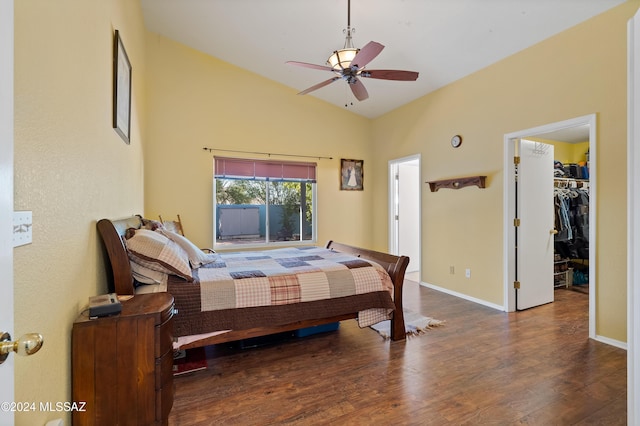 bedroom with a walk in closet, vaulted ceiling, dark hardwood / wood-style floors, ceiling fan, and a closet