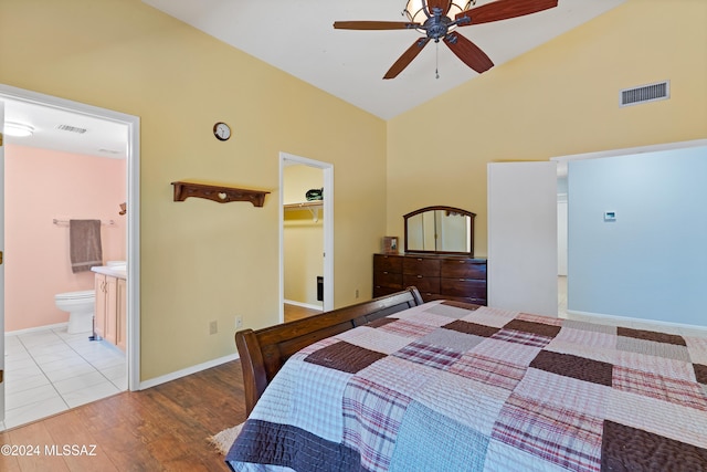 bedroom with hardwood / wood-style floors, a walk in closet, ensuite bath, ceiling fan, and a closet