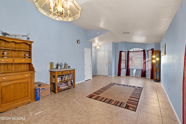 foyer entrance featuring lofted ceiling, light tile patterned floors, and a chandelier