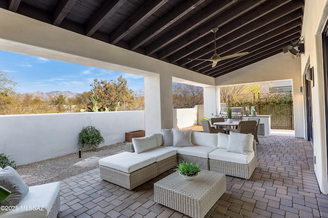 view of patio / terrace featuring ceiling fan, an outdoor living space, and a mountain view