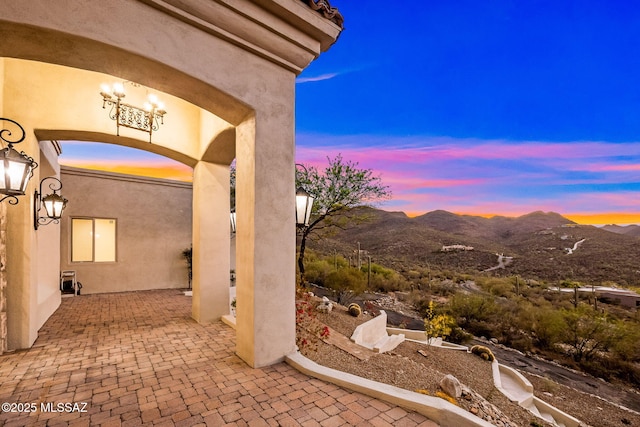 patio terrace at dusk featuring a mountain view