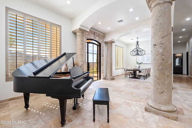 living area featuring a notable chandelier, recessed lighting, visible vents, ornate columns, and arched walkways