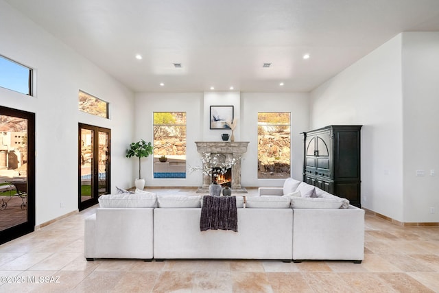 living area with visible vents, baseboards, recessed lighting, and a fireplace