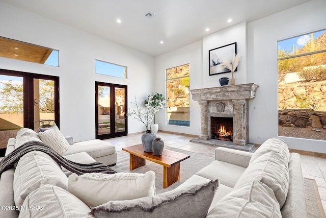 living room featuring recessed lighting, french doors, visible vents, and a premium fireplace
