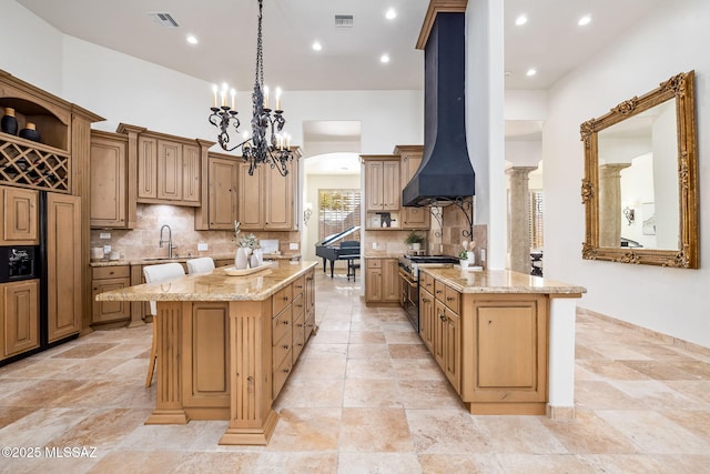 kitchen with a center island, extractor fan, high end stainless steel range, and visible vents
