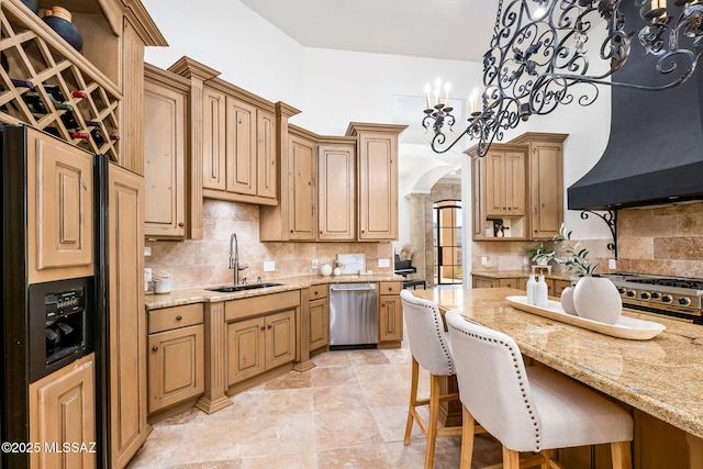 kitchen featuring a sink, wall chimney range hood, tasteful backsplash, and appliances with stainless steel finishes