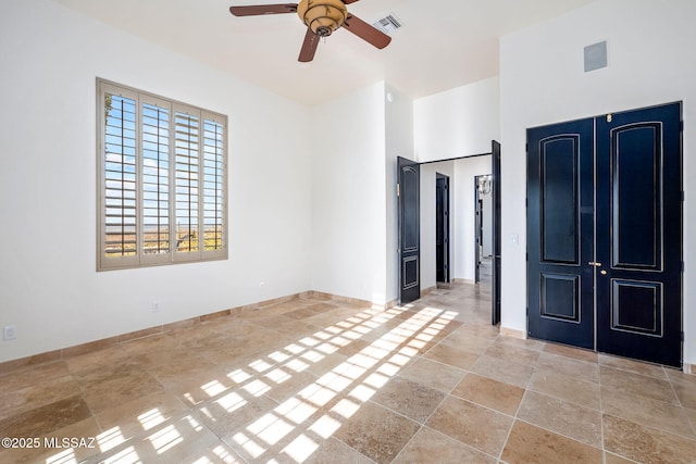 unfurnished bedroom featuring stone tile flooring, baseboards, and visible vents