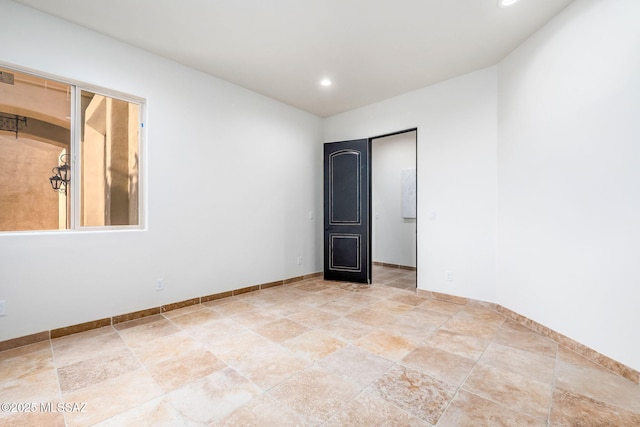 spare room featuring baseboards, recessed lighting, and stone finish flooring