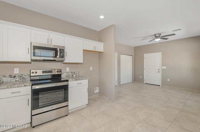 kitchen with white cabinets, stainless steel appliances, and light stone counters