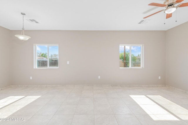 unfurnished room featuring a wealth of natural light, visible vents, and light tile patterned floors