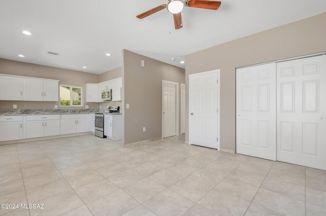 kitchen with stainless steel appliances, white cabinetry, light stone countertops, ceiling fan, and light tile patterned floors