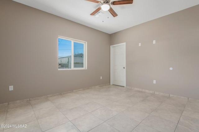 tiled empty room featuring ceiling fan