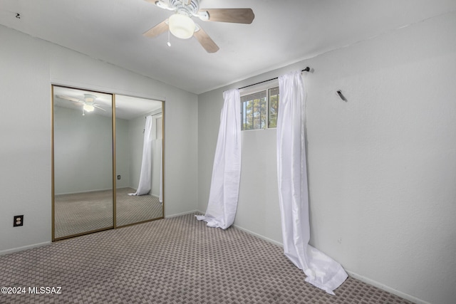 unfurnished bedroom with ceiling fan, light colored carpet, lofted ceiling, and a closet