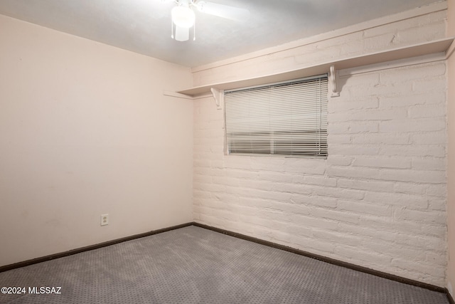 unfurnished room with carpet and brick wall