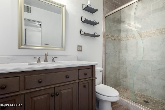 bathroom featuring an enclosed shower, vanity, toilet, and wood-type flooring