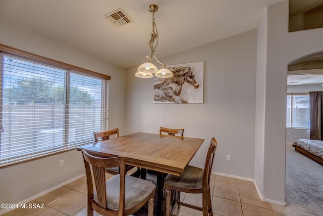 tiled dining space with ceiling fan and plenty of natural light