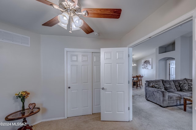 interior space with ceiling fan, light colored carpet, and vaulted ceiling