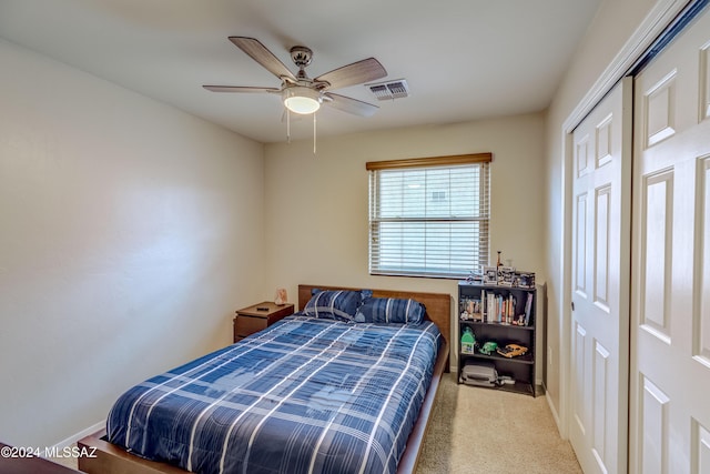 bedroom with ceiling fan, a closet, and light carpet