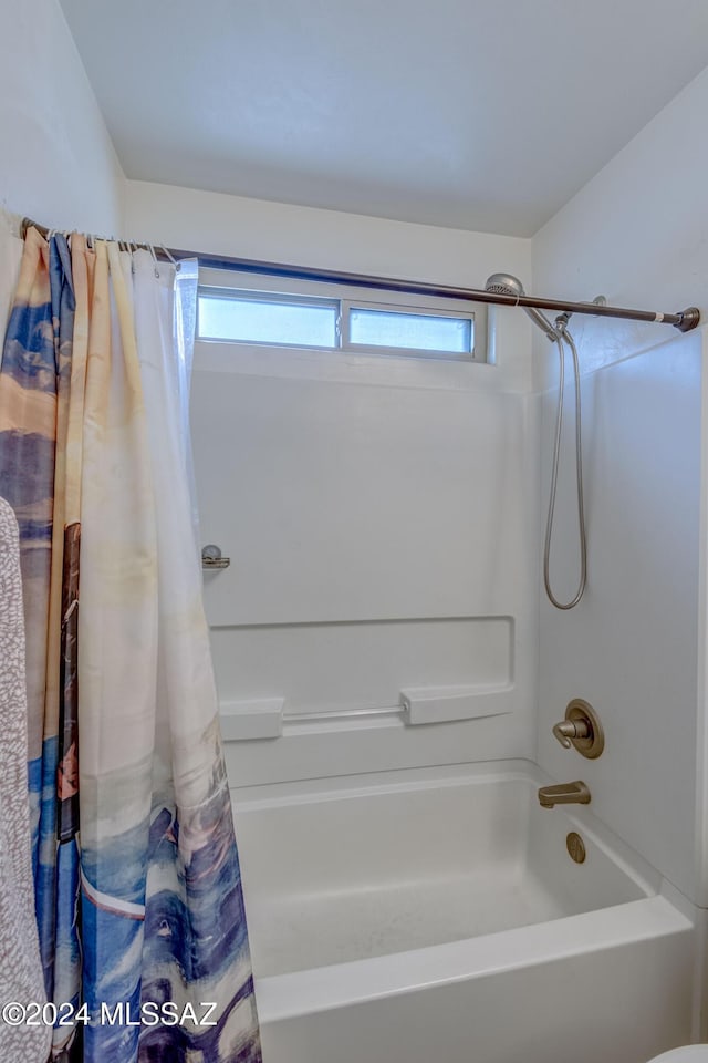 bathroom featuring a wealth of natural light and shower / tub combo