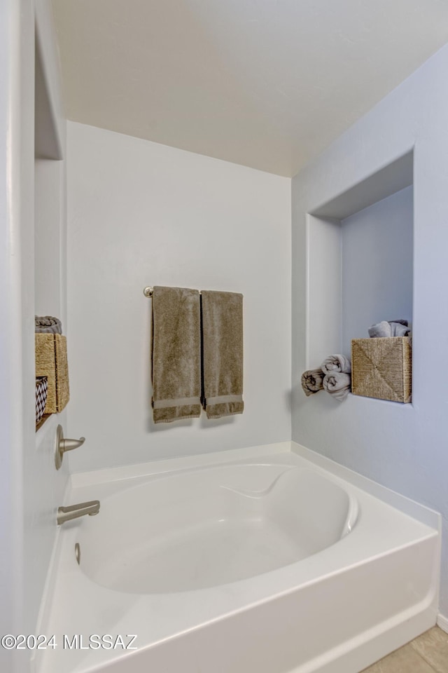 bathroom with a washtub and tile patterned floors