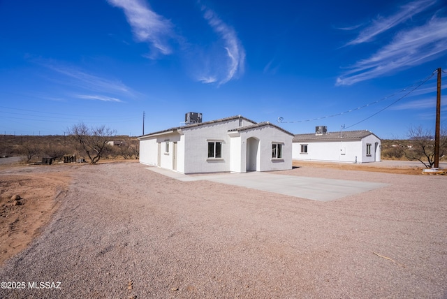 back of house featuring a patio area, central AC, and stucco siding