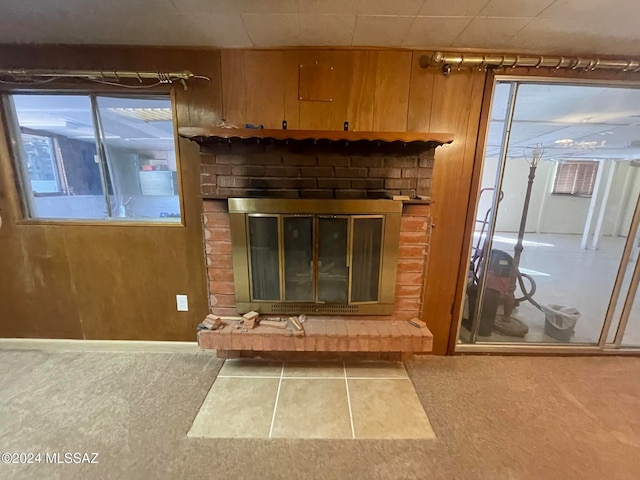 interior details featuring a brick fireplace and wood walls