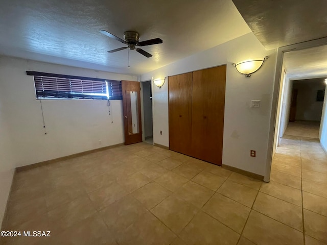 unfurnished bedroom featuring a closet, a textured ceiling, and light tile patterned floors