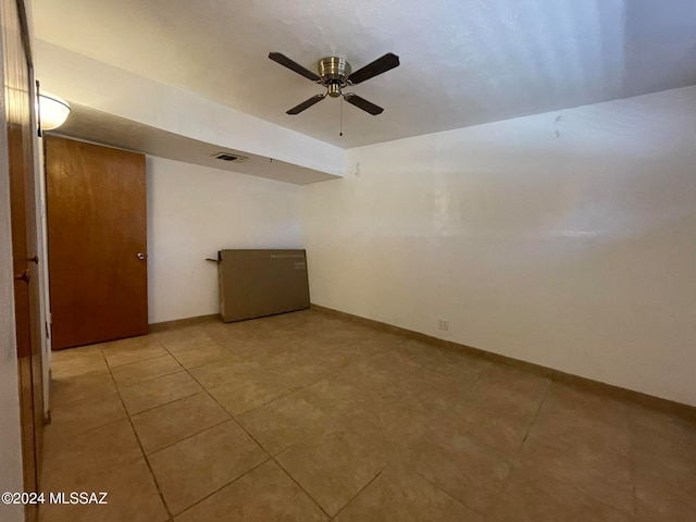 unfurnished room with light tile patterned floors and ceiling fan