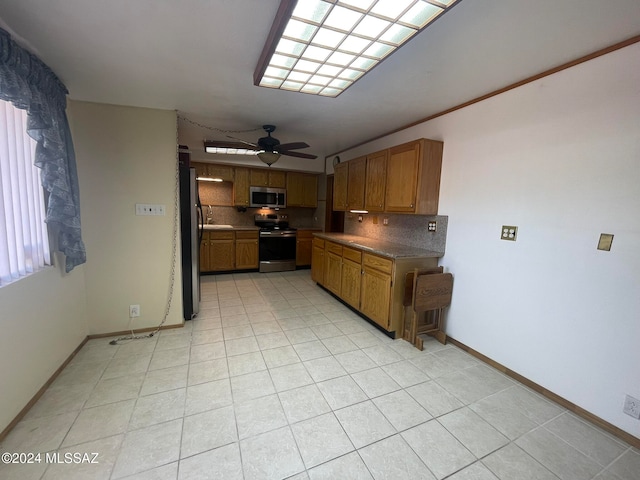 kitchen with tasteful backsplash, appliances with stainless steel finishes, light tile patterned floors, and ceiling fan