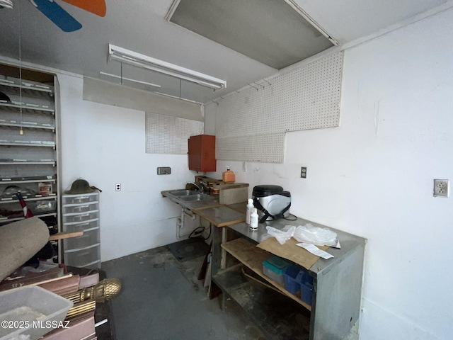 interior space with a sink, ceiling fan, and a workshop area