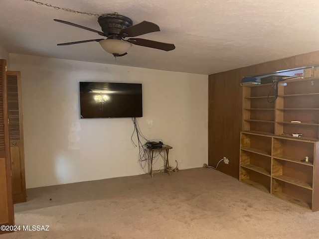 unfurnished living room featuring ceiling fan and carpet