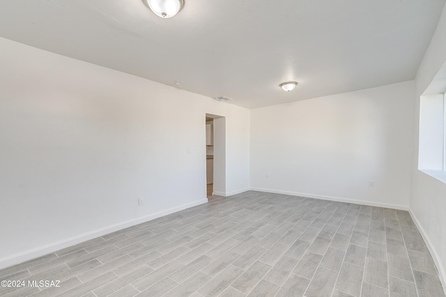 unfurnished room with light wood finished floors and baseboards