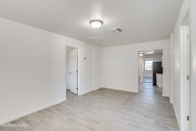 unfurnished room with light wood-style flooring, visible vents, and baseboards