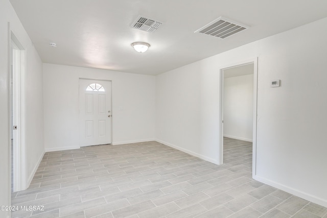 foyer entrance featuring baseboards and visible vents